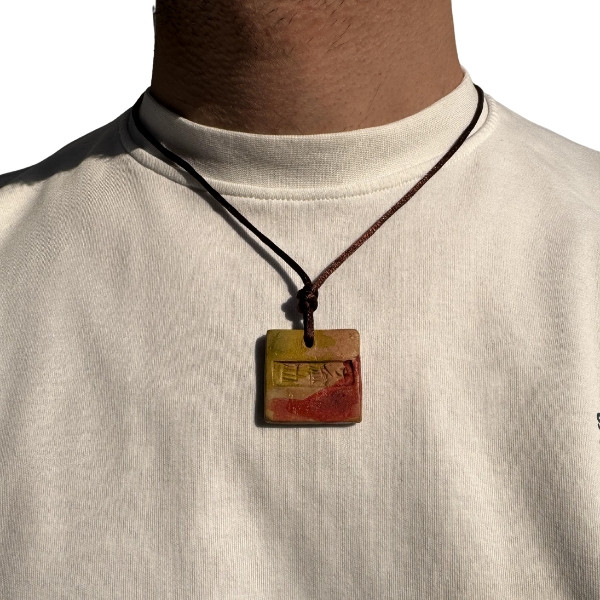 A Handmade Necklace in The Shape of a Sumerian Tablet Engraved with The Word Gilgamesh in Cuneiform Inscriptions